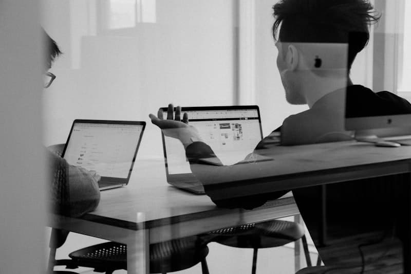 An editorial black and white photograph of a working technology discussion.